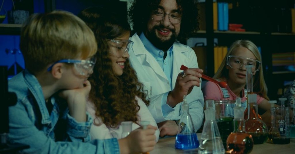 chemistry teacher with children doing classroom experiments