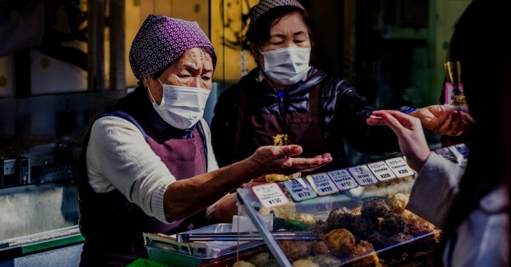 Asian workers in market selling food